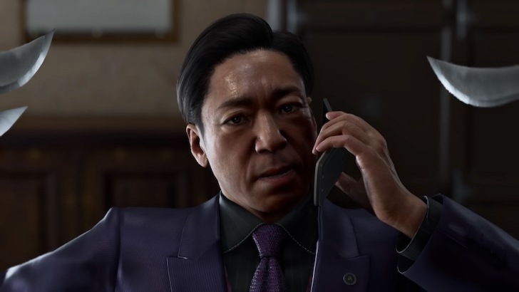 Goh Hamazaki speaking on a phone while knives are pointed at him