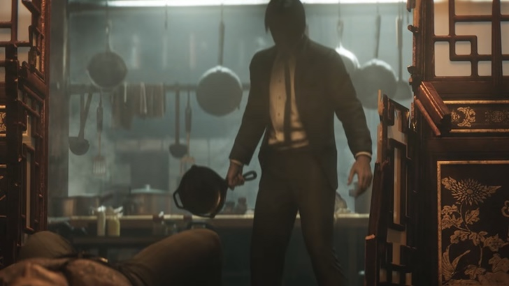 John Wick standing in a kitchen holding a pan, with a person lying on the floor