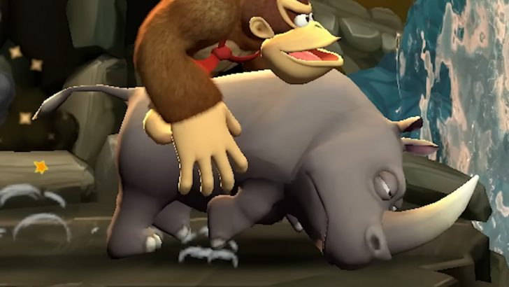 Rambi  charging to the right with Donkey Kong riding him, inside a cave with a waterfall to the righ