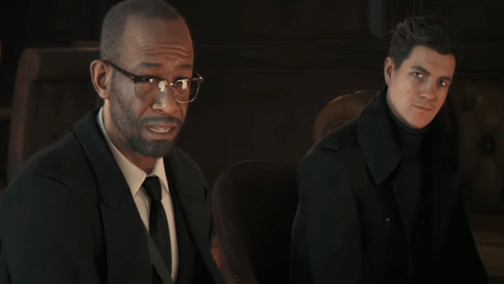 Greenway sitting beside Bond while talking to another person