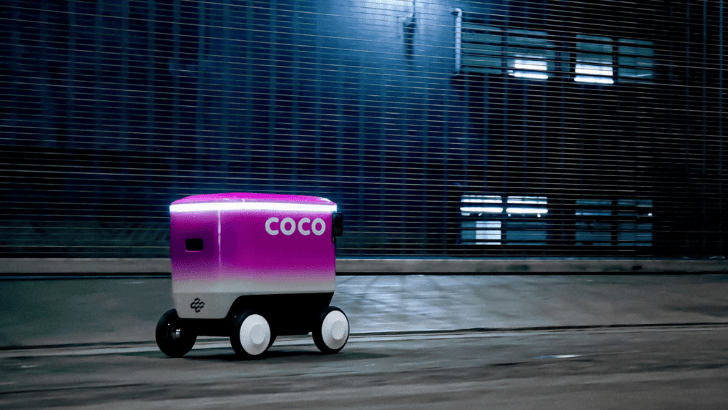 Coco robot on a sidewalk at night