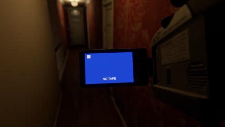 First person view of camcorder held in hallway with a blank blue screen that says No Tape