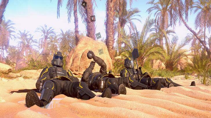 Helldivers 2 Three Helldivers lying on a sandy ground